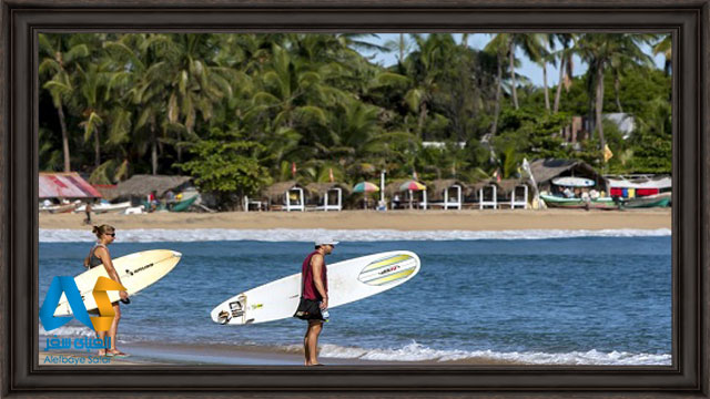 گردشگران در حال تفریح موج سواری در ساحل خلیج اروگام سریلانکا