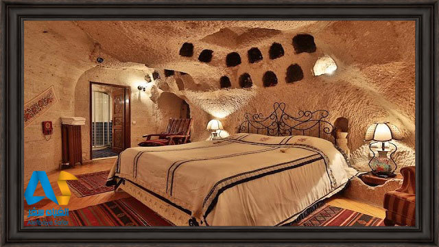 يكي از اتاق هاي سوئيت غار كاپادوكيه با تخت دونفره و مبلمان قديمي